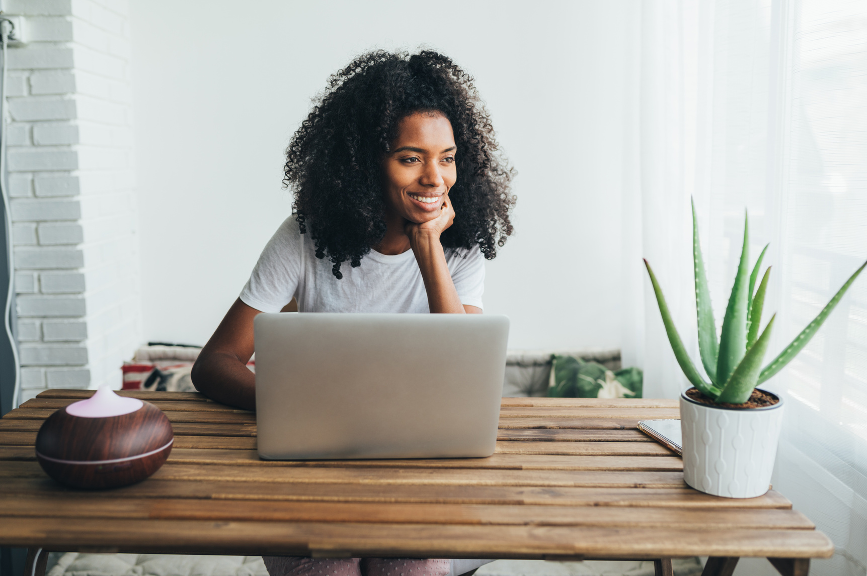 Young black woman using laptop at home